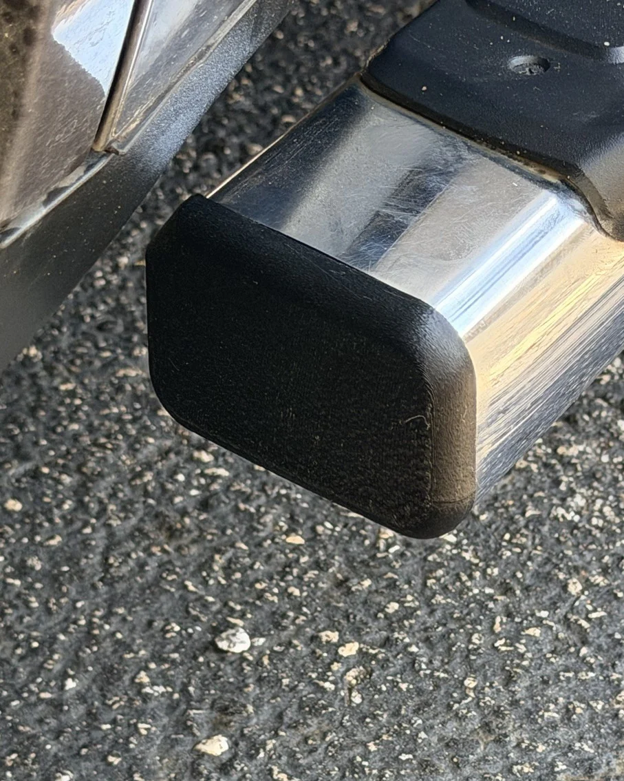 The matte black end cap, seated on a chrome running board.